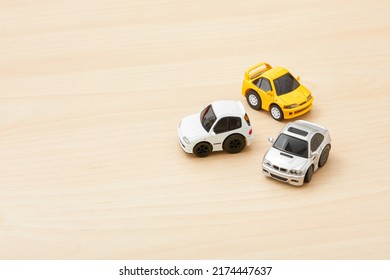 Tokyo, Japan. 25-06-22. Tiny Car Toy Isolated On Wood Background. Car Model. Toys. Miniature Toy. Kids Toy. Toy Collector. Space For Text.