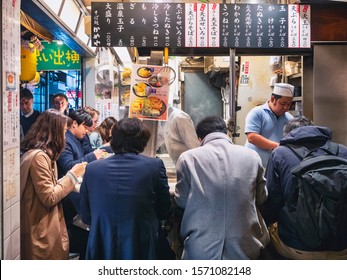 TOKYO, JAPAN - APR 12, 2019 : Tempura Noodle Shop With Japanese People Sitting At Counter Eat Noodle, Chef Cooking Food. Omoide Yokocho Bar Street Shinjuku