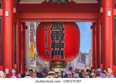 tokyo, japan - april 04 2020: Red wooden pillars of the Kaminarimon or Thunder gate of the Asakusa Sensō-ji temple ornate with the red paper lantern Fūraijinmon overlooking the tourists crowds.
