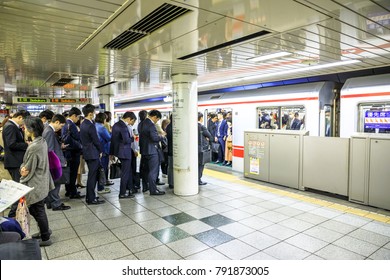 Tokyo, Japan - April 17, 2017: crowd of commuters waiting the Marunouchi Line, a subway line in red color and letter M, at Shinjuku Station, one of the most crowded railway lines in Tokyo.