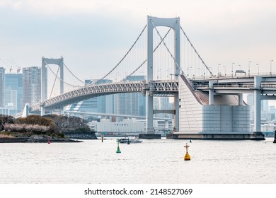 Tokyo, Japan - April, 2022: Landscape Of Rainbow Bridge, The Most Famous Bridge In Tokyo And Odaiba Area In A Cloudy Day