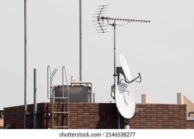 Tokyo, Japan - April, 2022: White KU Band Satellite Antenna (Dish) installed on the roof of apartment and high rise in Tokyo to receive BSCS 4K or 8K broadcast