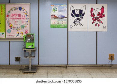 TOKYO, JAPAN - April 21, 2019: A Pay Phone In A Tokyo's TOEI Subway Station Next To Posters Of The Tokyo Olympic And Paralympic Mascots, Miraitowa And Someity.