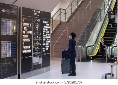 Tokyo, Japan - Aug 4,2020 Haneda International Airport, Business Man The Checking His Flight Schedule With Holding His Luggage And Wearing The Face Mask For The New Normal Travel On COVID-19 Period