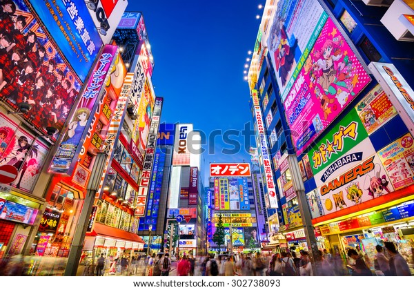 TOKYO, JAPAN - AUGUST 1, 2015: Crowds pass below\
colorful signs in Akihabara. The historic electronics district has\
evolved into a shopping area for video games, anime, manga, and\
computer goods.
