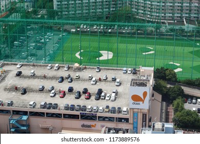 TOKYO, JAPAN - August 15, 2018: Overhead View Ofa Resdential Area In Tokyo's Edogawa Ward With A Supermarket Rooftop Car Park, A Golf Driving Range And An Apartment Block.