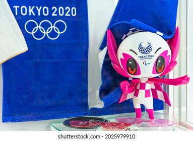 tokyo, japan - august 15 2021: Plastic figurine of the official mascot character Someity adorned with the Tokyo 2020 Paralympic Games logo and towels with the five-ringed emblem of the Olympic Games.