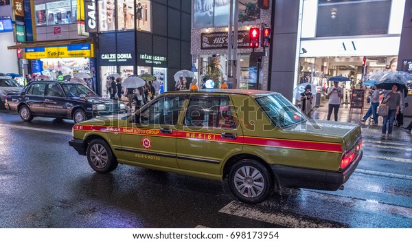 TOKYO, JAPAN - AUGUST 16TH, 2017. Taxi in\
Shinjuku street during a rainy\
night\
