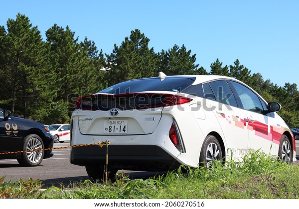 TOKYO, JAPAN - August 19, 2021: Cars including\
Toyota Prius PHV cars featuring the Tokyo Olympic and Paralympic\
logos parked in Tokyo\'s Koto Ward. They are part of a fleet of\
Tokyo Olympic vehicles.