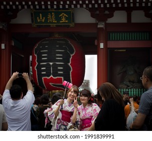 Tokyo, Japan - august 22 2019: Two Japanaese girls in kimonos taking a selfie among the crowd at the Sensō-ji gate