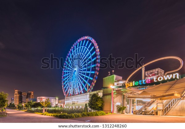 TOKYO, JAPAN - August 24 2018: Odaiba illuminated\
Palette Town Ferris wheel named Daikanransha visible from the\
central urban area of Tokyo in the summer night sky. Passengers can\
see the Tokyo Tower,