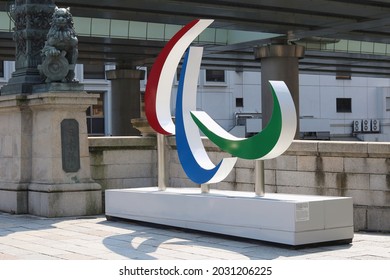 TOKYO, JAPAN - August 26, 2021: A Paralympic Symbol Monument By A Statue Of A Lion On Nihonbashi Bridge During The Tokyo Paralympics On A Hot Day.