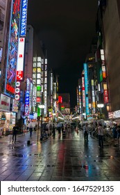 Tokyo, Japan - August 29, 2016: Shinjuku Nightlife Scene With Neon Lights And People. Text In Kanji Advertises Retail And Luxuty Shops And Eateries