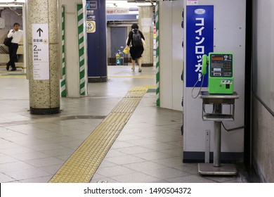 TOKYO, JAPAN - August 29, 2019: The Ginza Line's Toranomon Subway Station With A Pay Phone, Ockers, A Man Using A Mobile Phone, Columns And Ticket Gates In The Background.