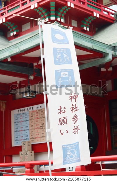 TOKYO, JAPAN - August 3, 2022: A banner about\
coronavirus safety precautions including mask wearing at Tomioka\
Hachiman Shrine, a Shinto shrine in Tokyo\'s Koto Ward. Selective\
focus.