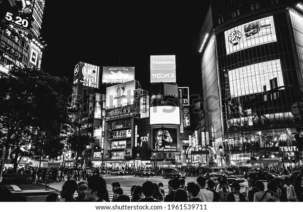 Tokyo, Japan - Circa 2015:\
Colorful panoramic view of the famous Shibuya crossing at Tokyo\
downtown with a crowd of people and traffic in the night (in black\
and white)