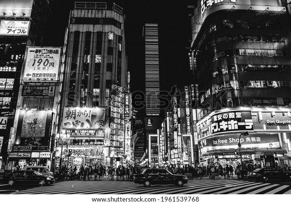 Tokyo, Japan - Circa 2015: People\
walking, night light, traffic, buildings, restaurants and stores at\
Shinjuku in the night (in black and\
white)