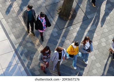 TOKYO, JAPAN - December 19, 2021: Overhead View Of A People On A Street In Tokyo's Harajuku Area On A Sunny Winter's Day. Some Motion Blur.