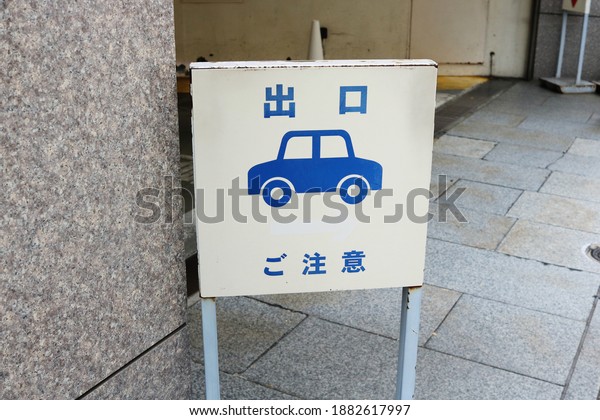 TOKYO, JAPAN - December 26, 2020: Sign on\
a street warning pedestrians of exiting cars. It is by a Mitsukoshi\
Department Store car park exit in\
Nihombashi.