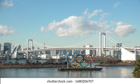 TOKYO, JAPAN - FEB 2020 : The Five Ring Symbol Of The Olympic Games In Front Of Odaiba Rainbow Bridge. Japan Will Host The Tokyo 2020 Summer Olympic And Paralympic. Shot In Day Time.