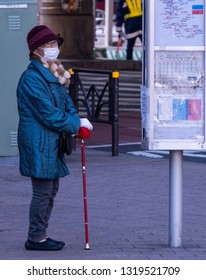 TOKYO, JAPAN - FEBRUARY 21ST, 2019. Elderly Woman Waiting For A Bus At A Shibuya Bus Stop During Winter Season.