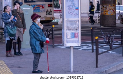 TOKYO, JAPAN - FEBRUARY 21ST, 2019. Elderly Woman Waiting For A Bus At A Shibuya Bus Stop During Winter Season.