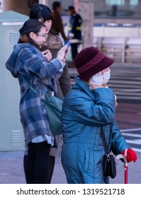 TOKYO, JAPAN - FEBRUARY 21ST, 2019. Elderly Woman Waiting For A Bus At A Shibuya Bus Stop During Winter Season.