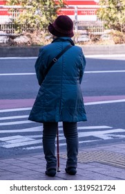 TOKYO, JAPAN - FEBRUARY 21ST, 2019. Elderly Woman Waiting For A Bus At A Shibuya Bus Stop During Winter Season.