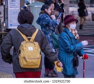 TOKYO, JAPAN - FEBRUARY 21ST, 2019. Elderly Woman Waiting For A Bus At A Shibuya Bus Stop During Winter Season.