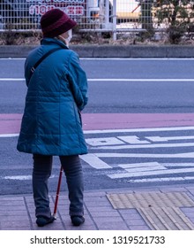 TOKYO, JAPAN - FEBRUARY 21ST, 2019. Elderly Woman Waiting For A Bus At A Shibuya Bus Stop During Winter Season.