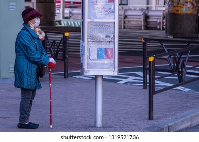 TOKYO, JAPAN - FEBRUARY 21ST, 2019. Elderly Woman Waiting For A Bus At A Shibuya Bus Stop During Winter Season.