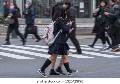 TOKYO, JAPAN - FEBRUARY 27TH, 2019. Japanese school girls crossing the famous Shibuya scramble crosswalk in winter. - Shutterstock ID 1325423990