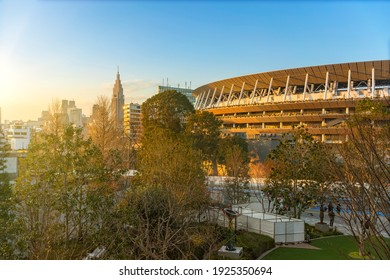 Tokyo, Japan - February 8 2021: High Angle Sunset View Of The 2020 Olympic National Stadium In Front Of The  Japan Sport Olympic Square With The NTT Docomo Yoyogi Building In Background.