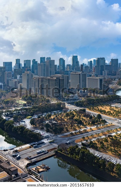 tokyo, japan - january 02 2021: Bird\'s-eye\
view of the national park of Kokyo Gaien National Garden in Tokyo\
Imperial Palace with the Hibiya Park and the skyscrapers of\
Kasumigaseki in\
background.