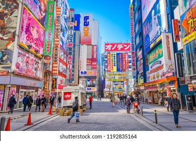 TOKYO, JAPAN - JANUARY 11, 2017: Crowds pass below colorful signs in Akihabara. The historic electronics district has evolved into a shopping area for video games, anime, manga, and computer goods.