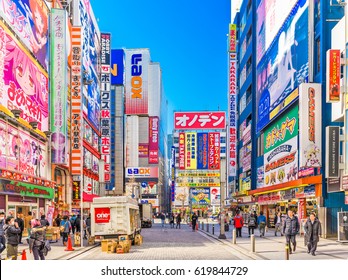 TOKYO, JAPAN - JANUARY 11, 2017: Crowds pass below colorful signs in Akihabara. The historic district electronics has evolved into the shopping area for video games, anime, manga, and computer goods.