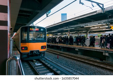 Tokyo, Japan - January 21, 2020: The Orange Line Train Is Entering The Platform To Pick Up Passengers.