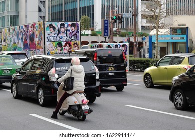 TOKYO, JAPAN - January 22, 2020: Traffic In Tokyo's Aoyama Area Including An Ad Truck Promoting A Band, Taxis And A Scooter. A Subway Station Entrance Is In The Background.