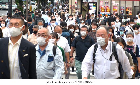 TOKYO, JAPAN - JUL 2020 : Crowd Of People At The Street Near Shinjuku Station In Rush Hour. Commuters Wearing Surgical Mask To Protect From Coronavirus (COVID-19) In Hot Summer Season.