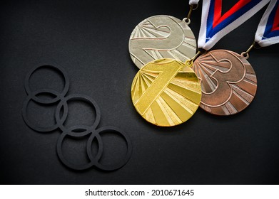 TOKYO, JAPAN, JULY. 19. 2021: Medal set, gold silver and bronze and olympic logo on black background. Medal Table concept photo