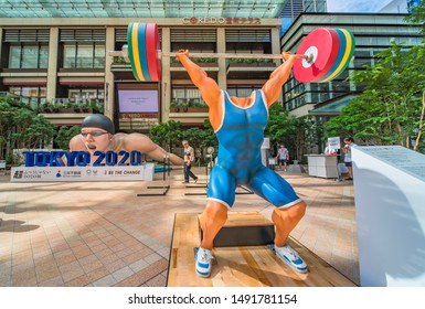 Tokyo, Japan - July 26 2019: Event for the Tokyo Olympic Games in 2020. Passers-by could test Weight Lifter Face Saddle to rediscover the limits exceeded by athletes.A face doll of a weightlifting.