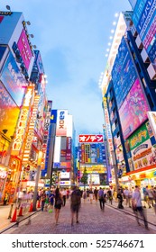 Tokyo, Japan - July 29, 2015: Bright neon lights and billboard advertisements on building sides in busy Akihabara electronics hub during blue hour on a summer night in downtown. Vertical