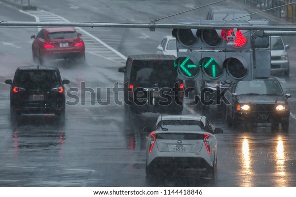 TOKYO, JAPAN - JULY 29TH, 2018.\
Vehicles in the street of Shibuya during typhoon rainy\
season.