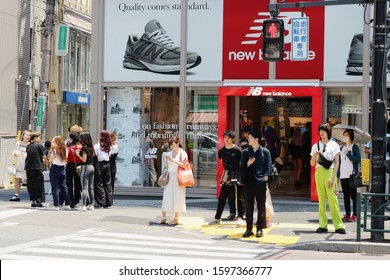 TOKYO, JAPAN - June 13, 2019: A  New Balance Store In Tokyo's Harajuku Area And The Busy Sidewalk In Front Of It.