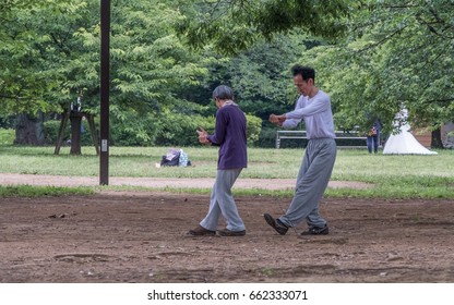 TOKYO, JAPAN - JUNE 18TH 2017. Elderly Couple Practicing Taichi In Yoyogi Park. The Park Is A Very Popular Public In Tokyo And Is A Favorite Destination For Recreational Activities In Tokyo.