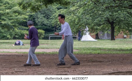 TOKYO, JAPAN - JUNE 18TH 2017. Elderly Couple Practicing Taichi In Yoyogi Park. The Park Is A Very Popular Public In Tokyo And Is A Favorite Destination For Recreational Activities In Tokyo.