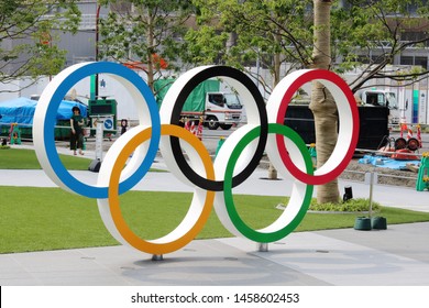 TOKYO, JAPAN - June 21, 2019: Olympic Rings monument at Tokyo Sport Olympic Square, the headquarters of JSPO & JOC. Opposite is  the under-construction National Stadium being built for 2020 Olympics.