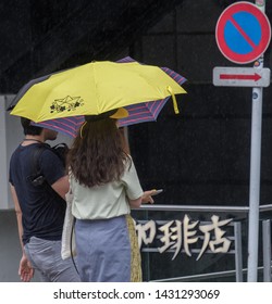 TOKYO, JAPAN  - JUNE 21ST, 2019. Couple With Umbrella During A Rainy Day At Takeshita Dori Street, Harajuku.