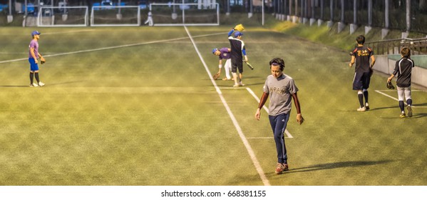 TOKYO, JAPAN - JUNE 28TH 2017. Players Practicing Baseballs At Night. Baseball Is A Popular Sport In Japan.