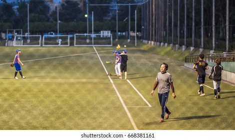 TOKYO, JAPAN - JUNE 28TH 2017. Players Practicing Baseballs At Night. Baseball Is A Popular Sport In Japan.